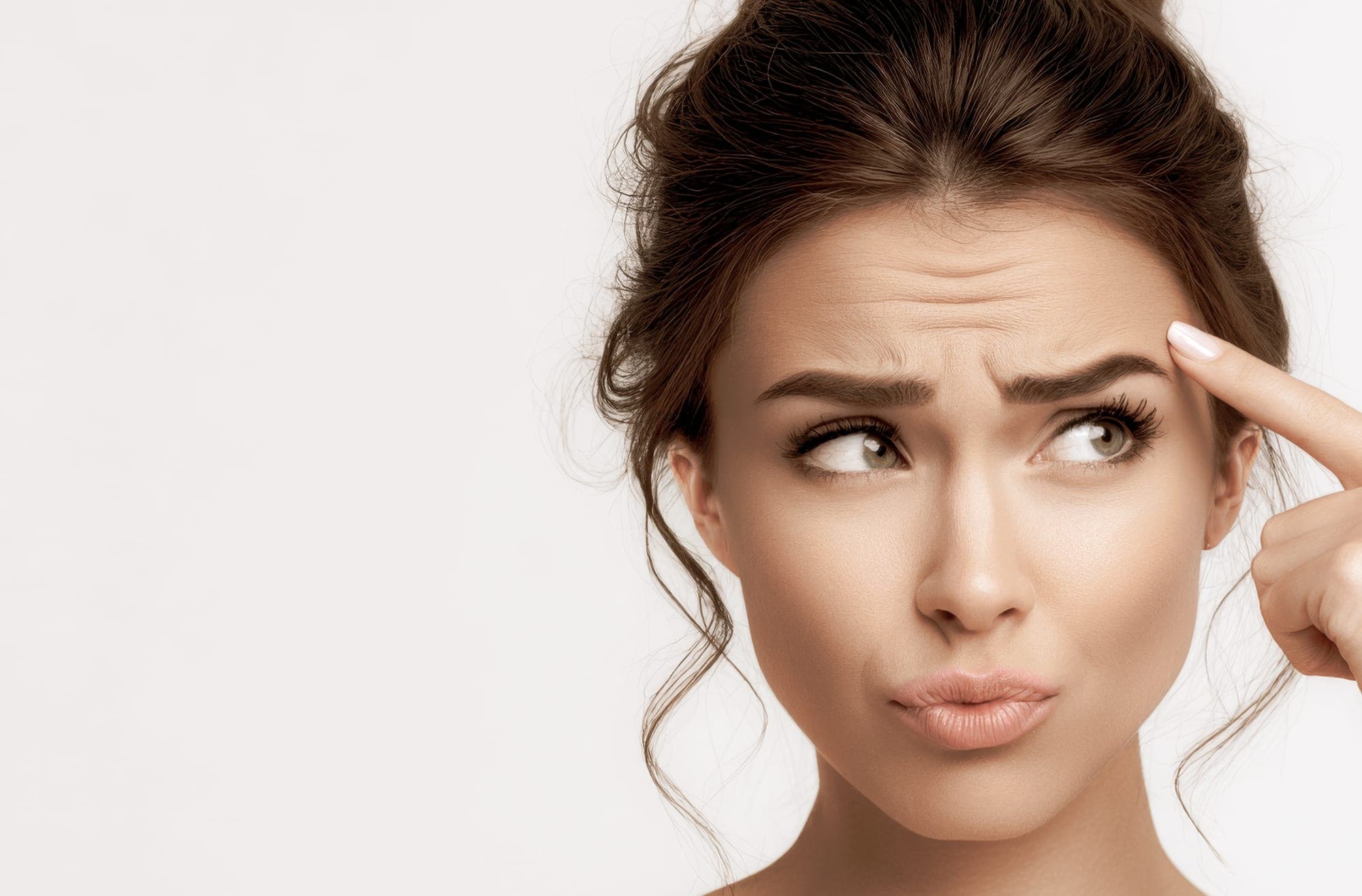 Woman pointing to forehead lines - Fine Lines & Wrinkles Treatment