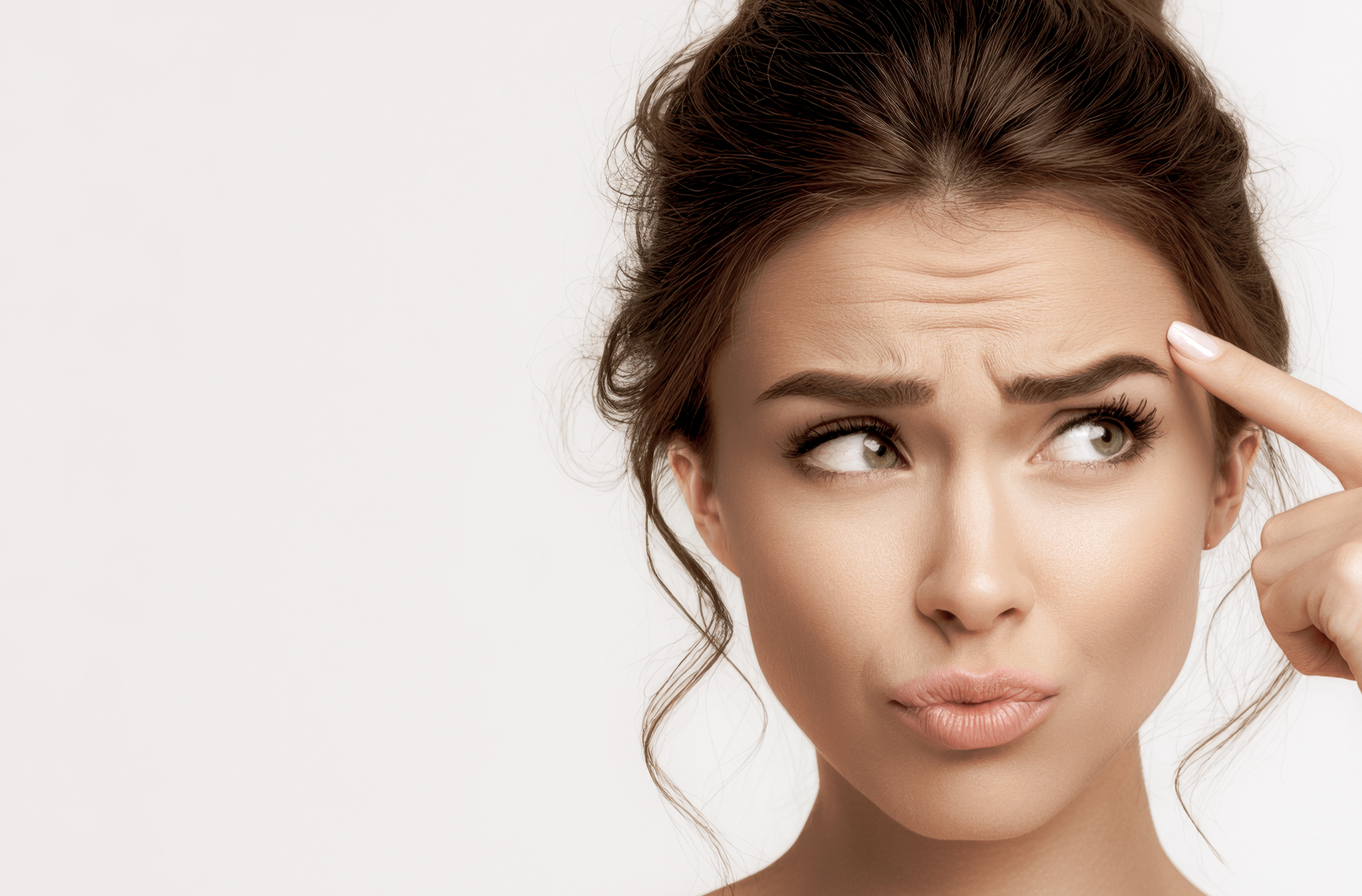 Woman pointing to forehead lines - Fine Lines & Wrinkles Treatment